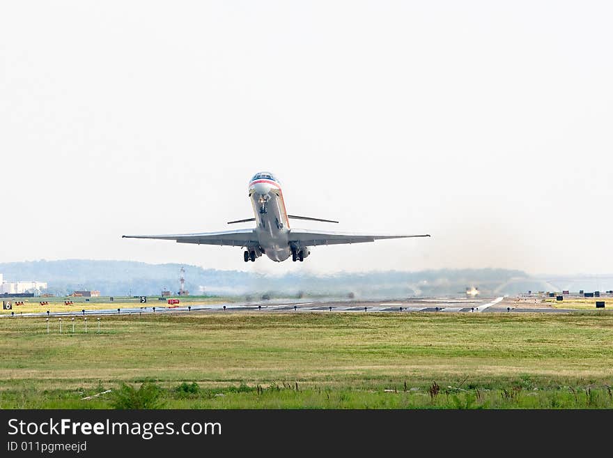 A passenger airplane takes off from a busy strip with another aircraft waiting for clearance. A passenger airplane takes off from a busy strip with another aircraft waiting for clearance