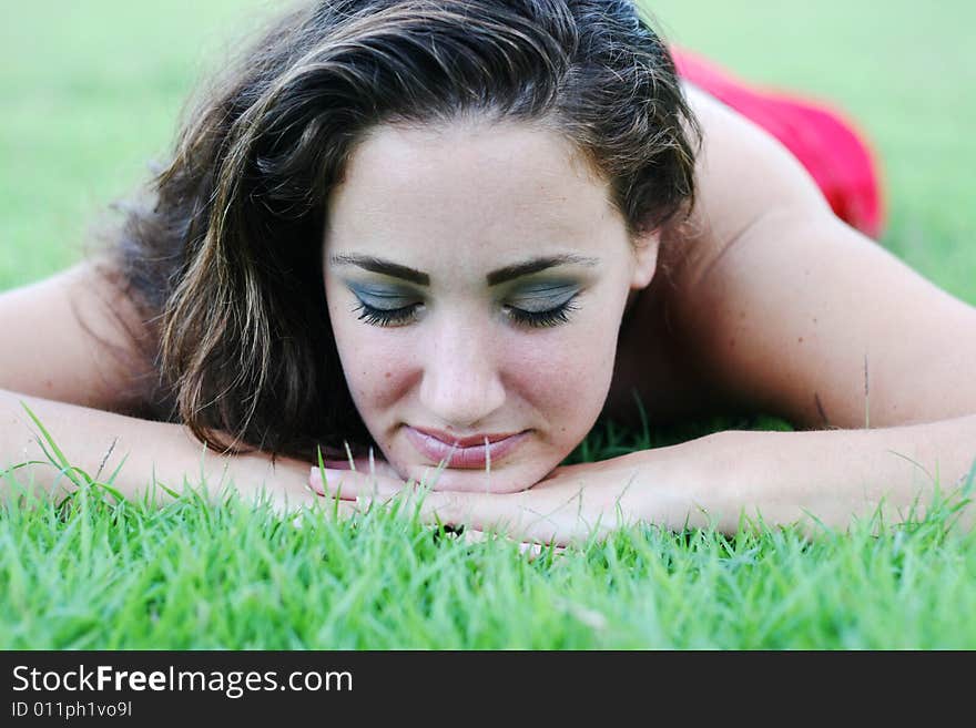 Close-up portrait of a woman relaxing outside with her eyes closed.