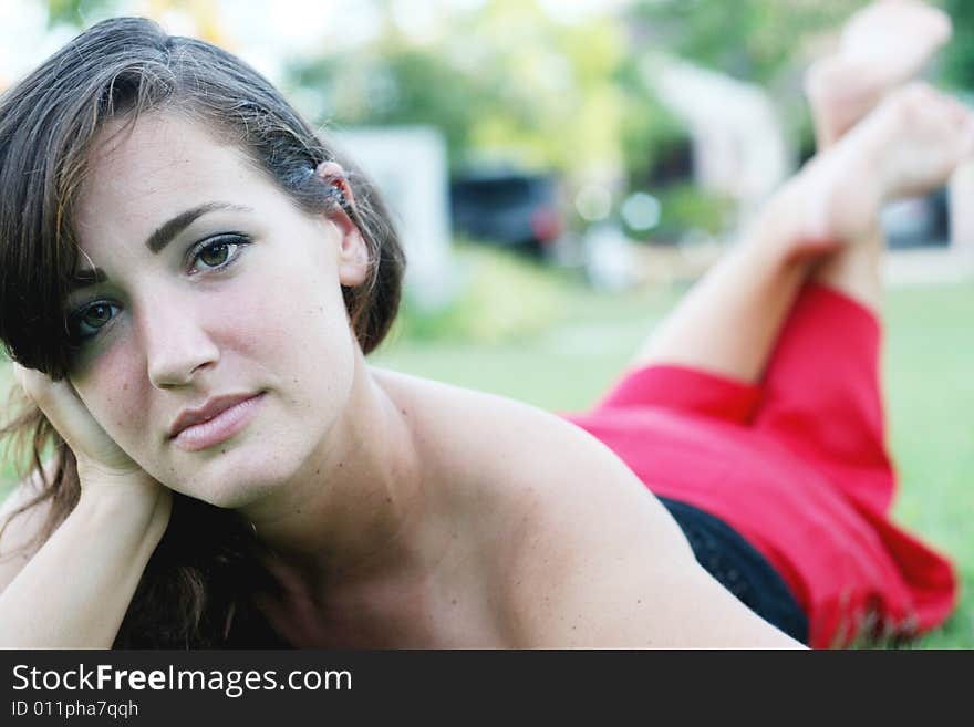 Portrait of a beautiful woman laying on the grass.