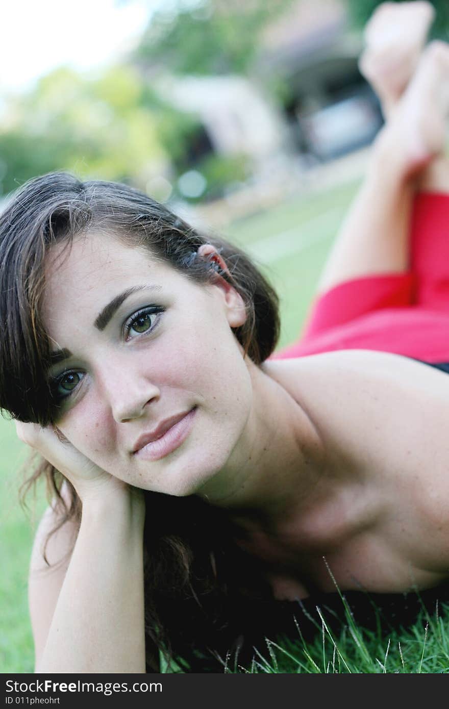 Portrait of a beautiful woman laying on the grass.