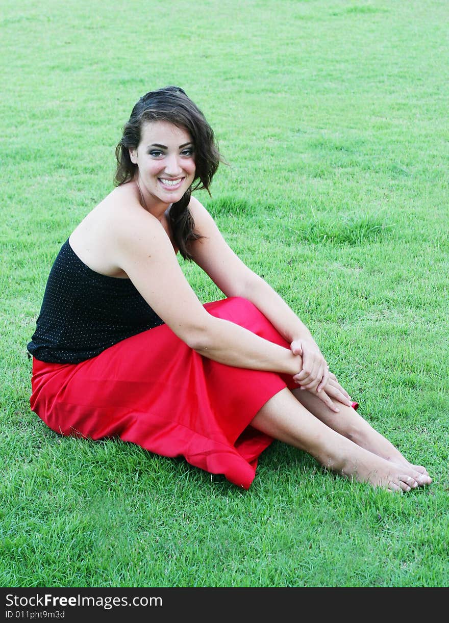 Portrait of a beautiful woman sitting on the grass.