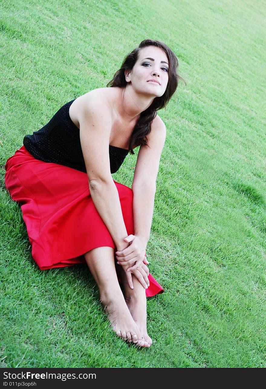 Portrait of a beautiful woman sitting on the grass.