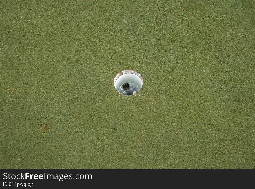 The round hole on a golf course green. The round hole on a golf course green