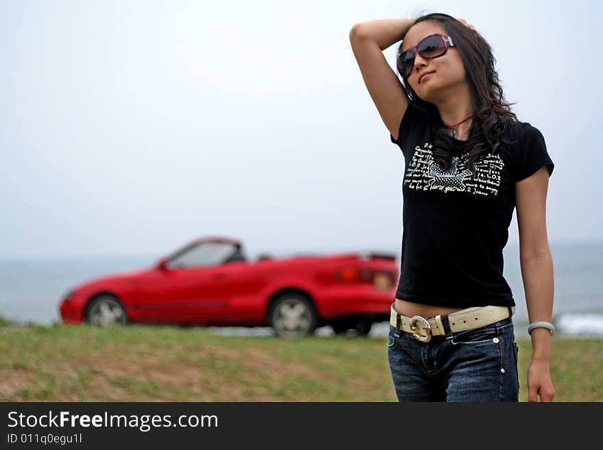 A chinese model and a red car at seaside ,bohai sea,china. A chinese model and a red car at seaside ,bohai sea,china.