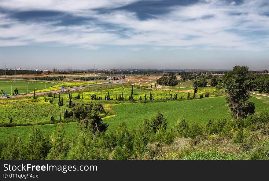 View on green fields and blue sky with clouds at spring time in Israel. View on green fields and blue sky with clouds at spring time in Israel.