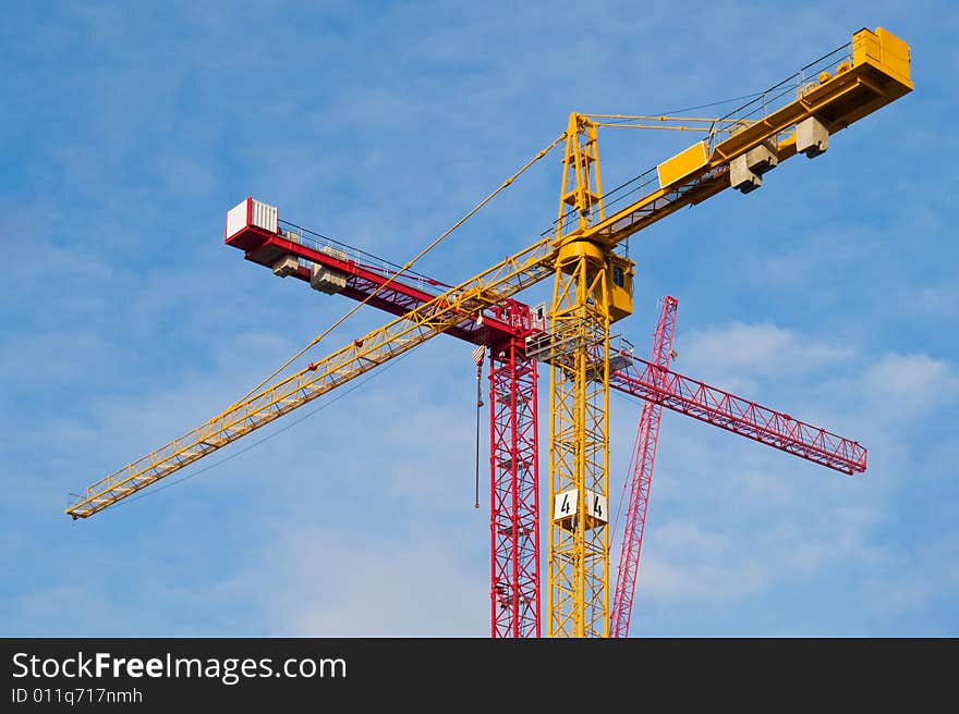 Red and yellow cranes over sky background. Red and yellow cranes over sky background