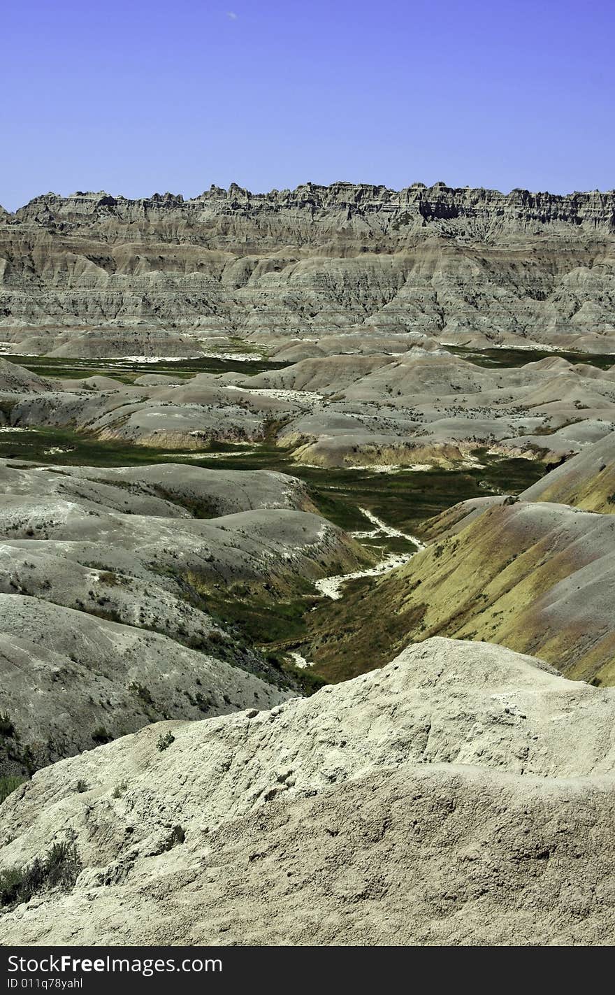 Colorful Badland mountains separated by green grass and dry river beds in South Dakota, USA. Colorful Badland mountains separated by green grass and dry river beds in South Dakota, USA