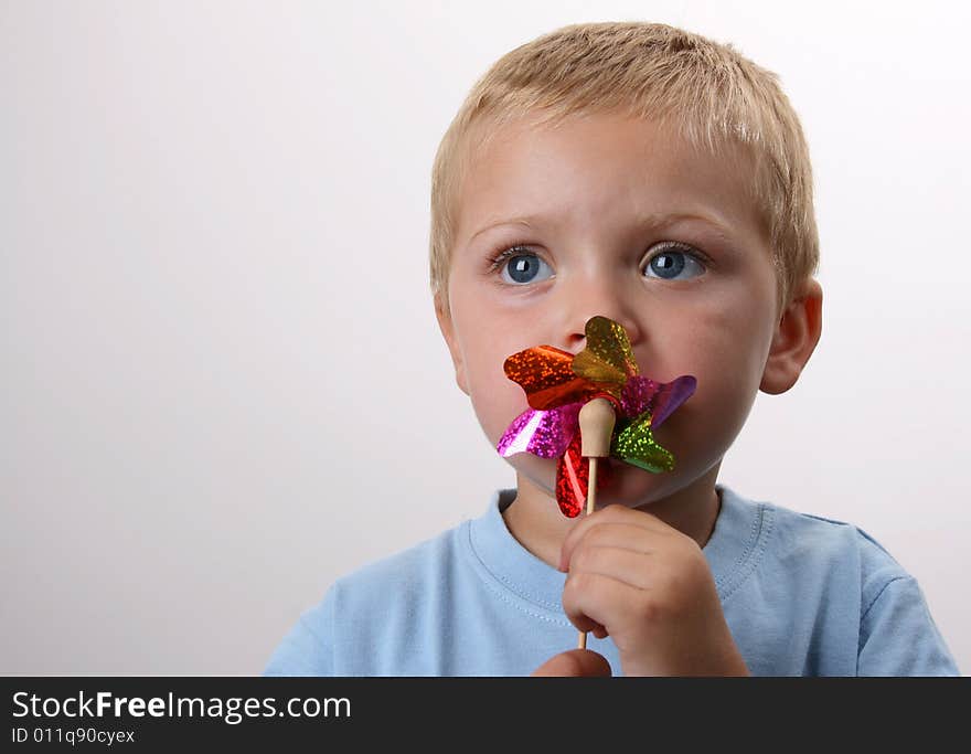 Toddler playing with a wind toy made of bright colors. Toddler playing with a wind toy made of bright colors