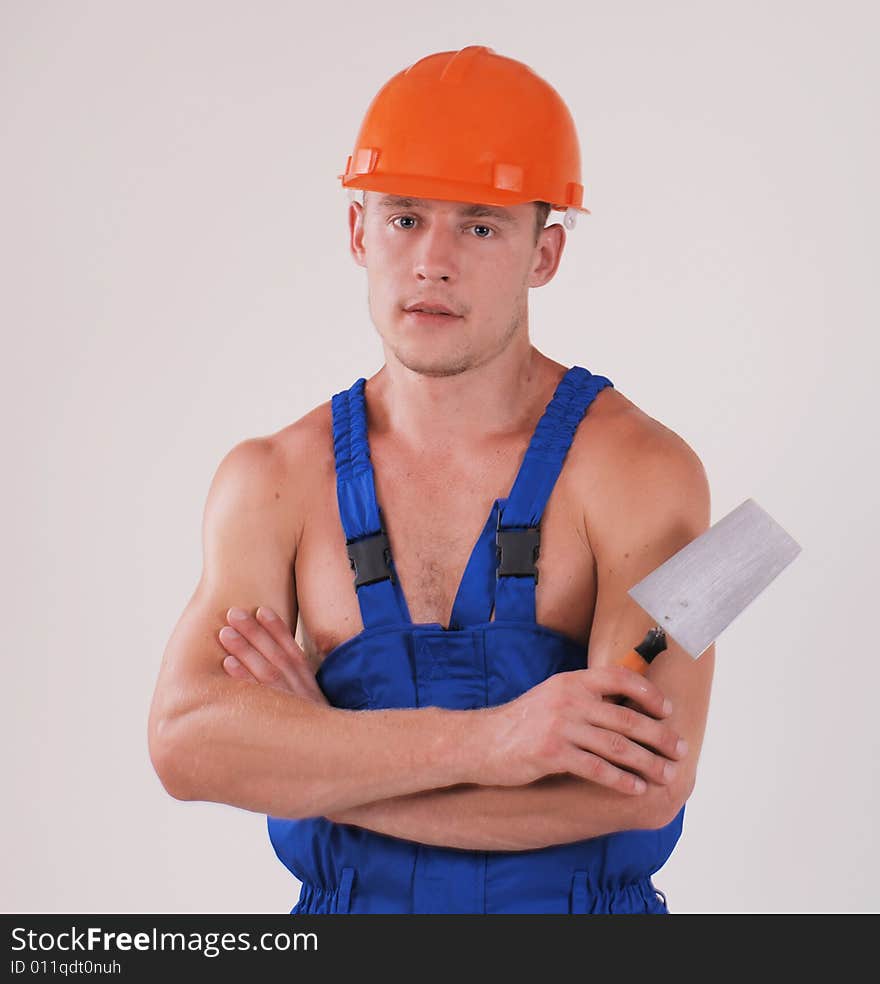 Worker in blue uniform and helmet with trowel. Worker in blue uniform and helmet with trowel