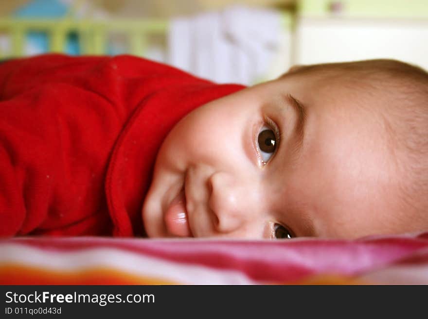 Happy baby lying on a bed