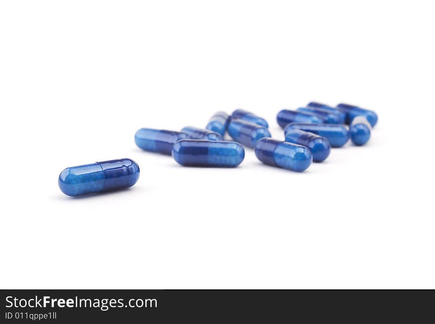 Group of blue pills isolated on white background. Shallow depth of focus