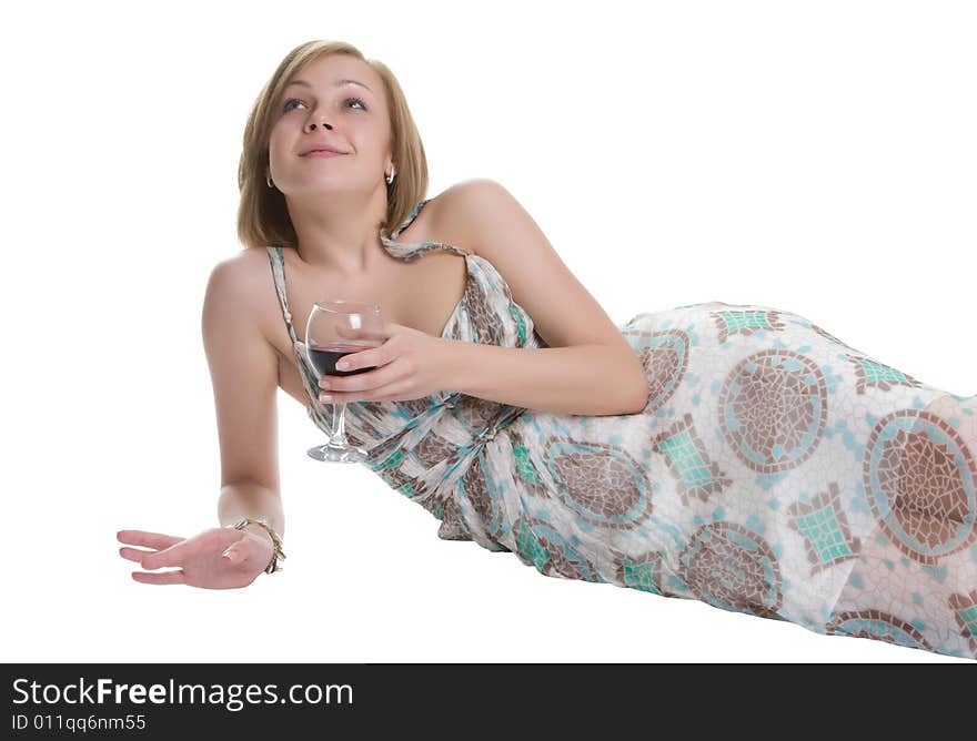 Beautiful woman lays on a white background with a glass of red wine in a hand. Beautiful woman lays on a white background with a glass of red wine in a hand