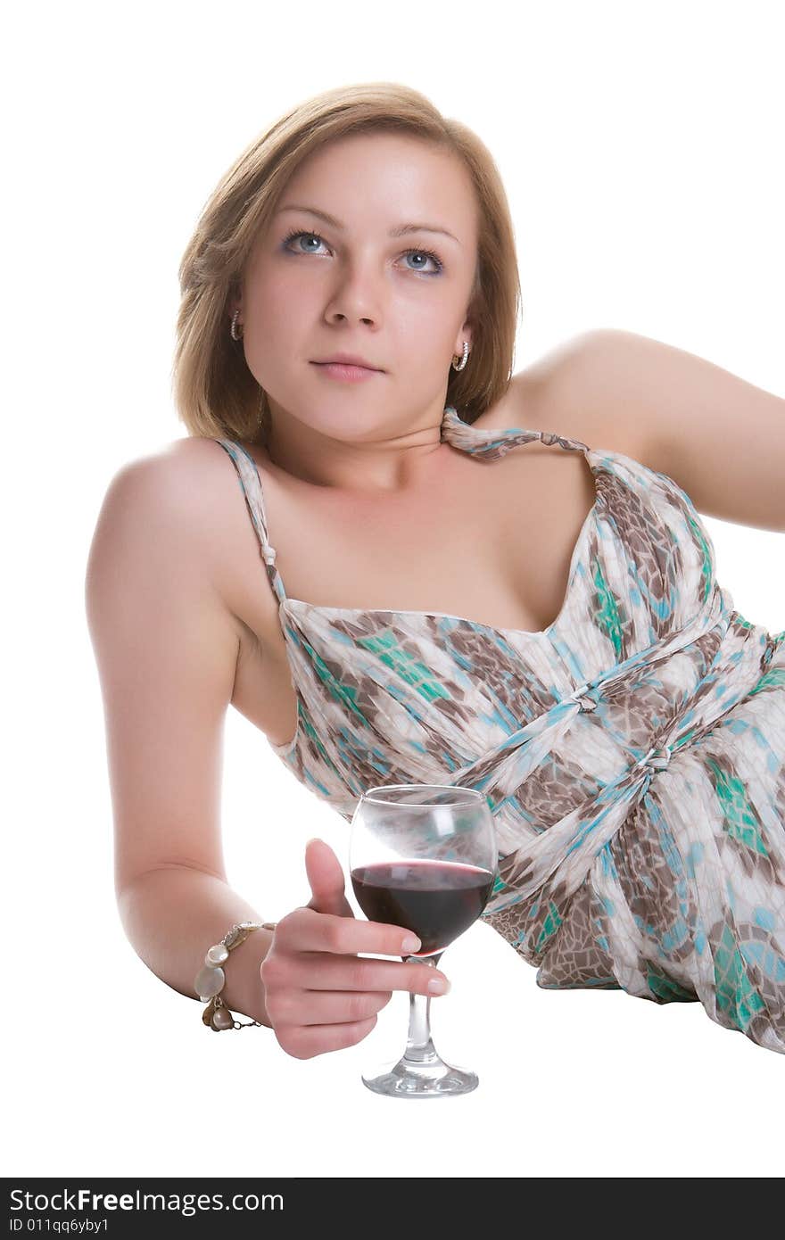 Beautiful woman lays on a white background with a glass of red wine in a hand. Beautiful woman lays on a white background with a glass of red wine in a hand