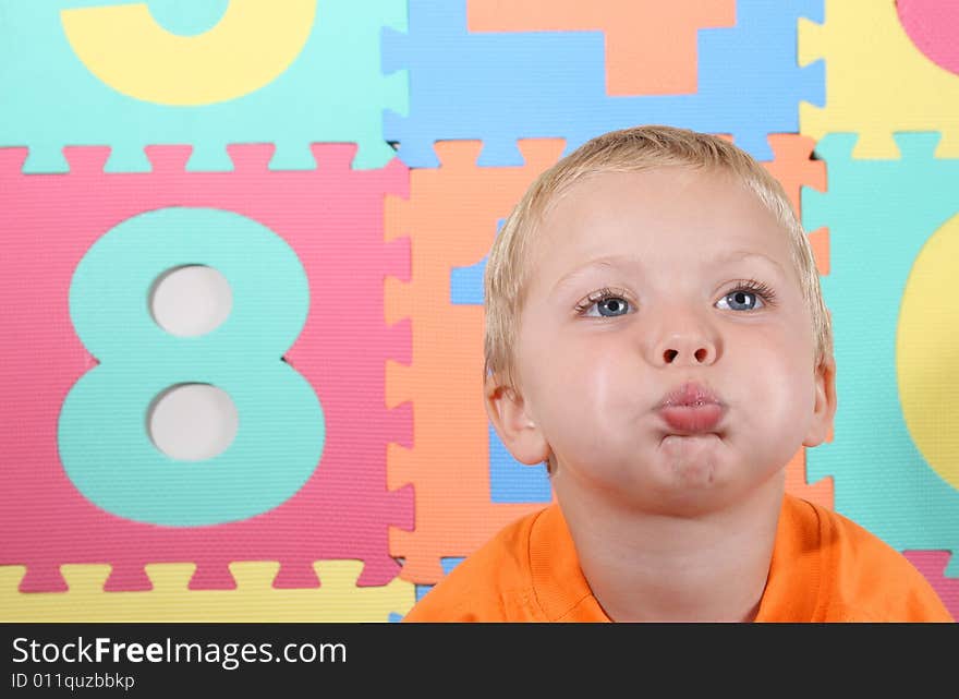 Blond Toddler playing against a colorful background. Blond Toddler playing against a colorful background