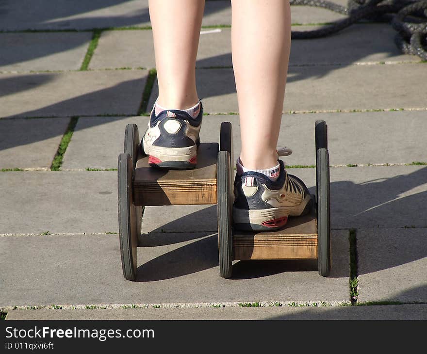 The boy goes for a drive on asphalt on old wooden rollers