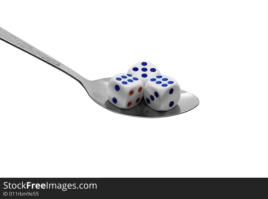 Metal spoon with dices on white background