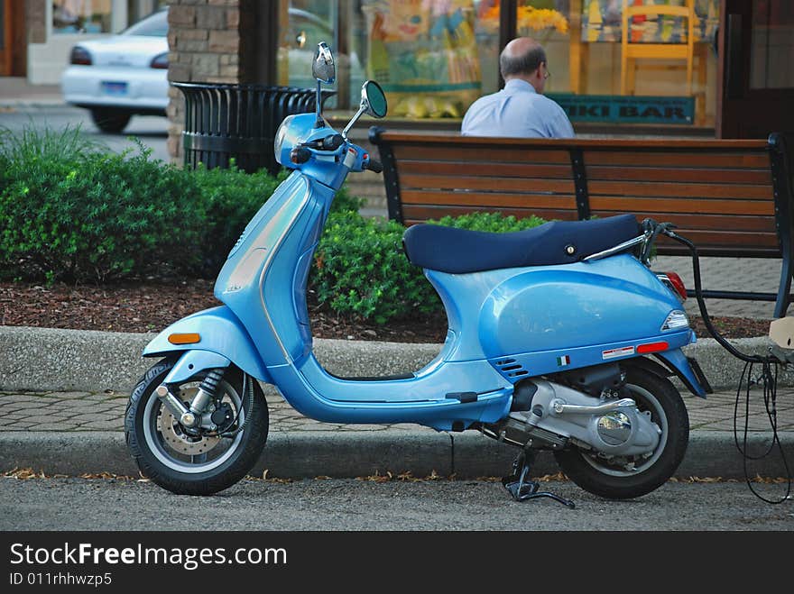 New baby blue moter scooter parked at the curb. New baby blue moter scooter parked at the curb.