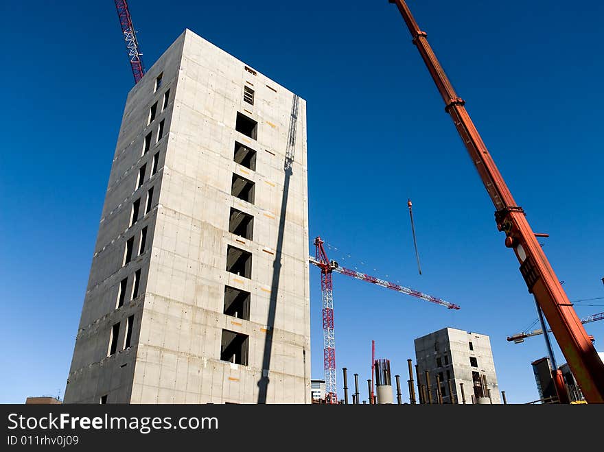 Concrete structure and cranes against a limpid sky. Concrete structure and cranes against a limpid sky