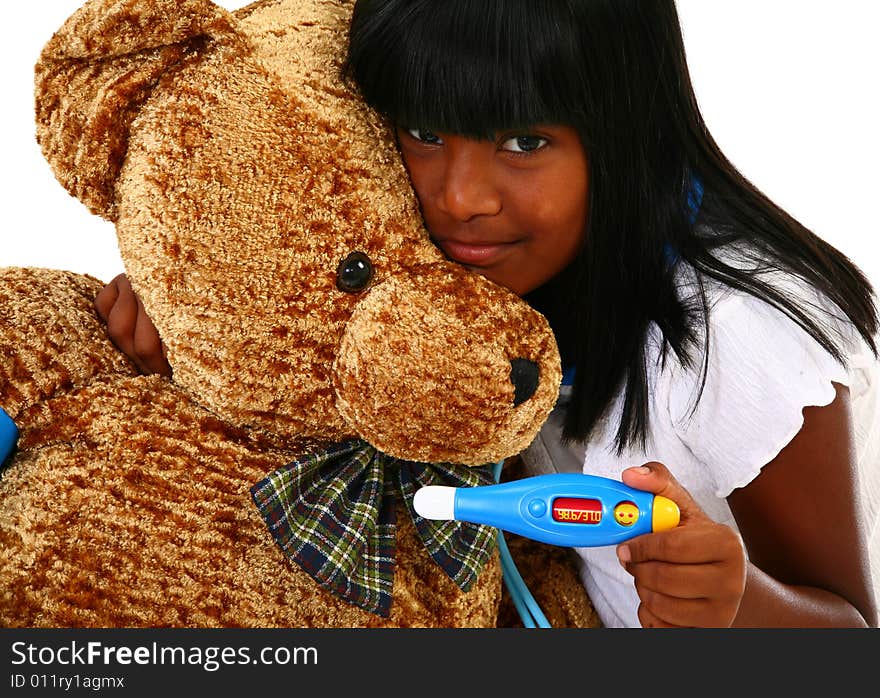 Beautiful 10 year old Indian girl playing doctor to a giant teddy bear. Beautiful 10 year old Indian girl playing doctor to a giant teddy bear.