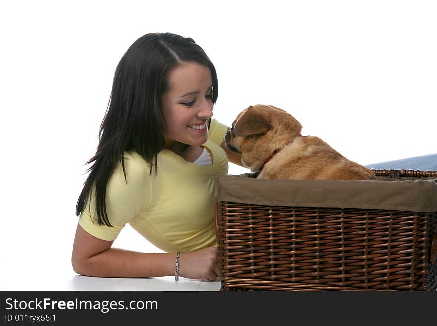 Cute teen leaning in toward little pug dog in wicker basket. Cute teen leaning in toward little pug dog in wicker basket