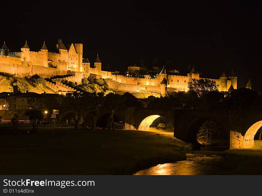 In old Carcassonne, the walls of the medieval city and the Pont Vieux bridge are illuminated at night. In old Carcassonne, the walls of the medieval city and the Pont Vieux bridge are illuminated at night.
