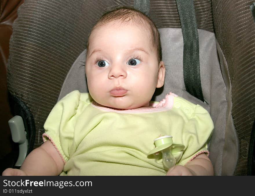 Beautiful baby girl with her dummy.