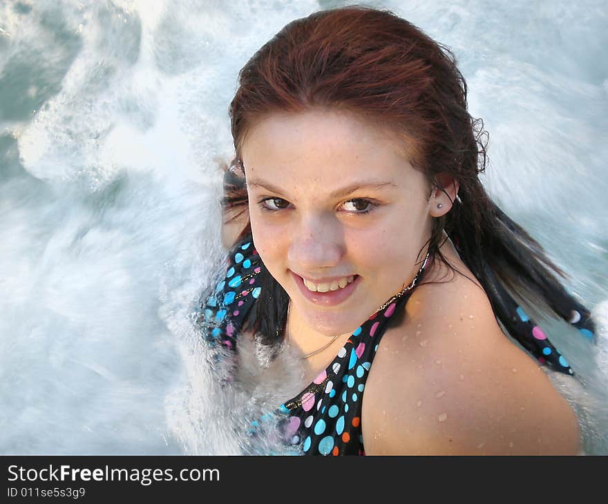 A picture of a white young girl in a polka dot bikini in a jacuzzi.