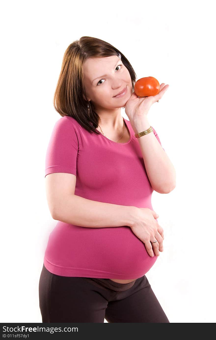 Pretty happy pregnant woman with a tomato against white background