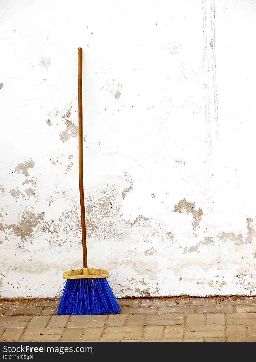 The wooden brush against the white wall.