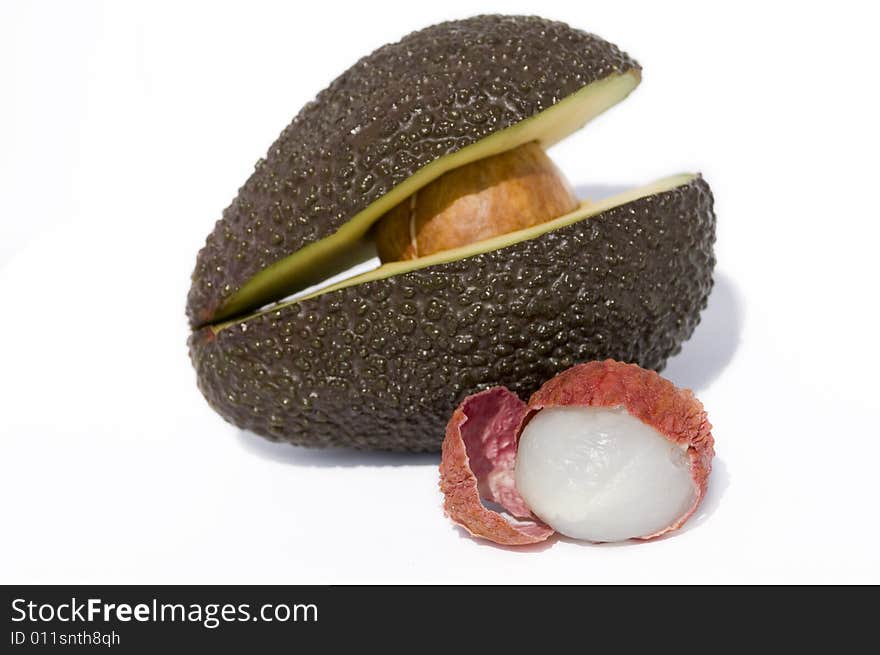 Two half of avocado with seed and litchi. Two half of avocado with seed and litchi