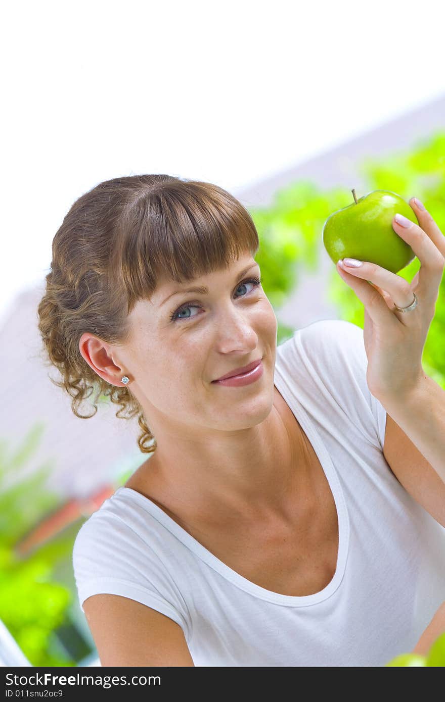 High key portrait of young woman with apple. High key portrait of young woman with apple