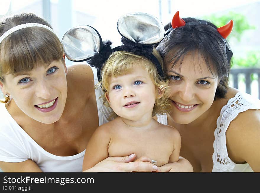 Portrait of two young woman and little baby in between. Portrait of two young woman and little baby in between