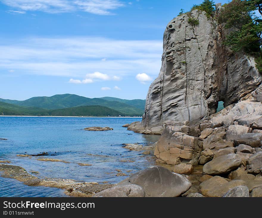 A very small bay among fancy rocks. Seacoast of Petrova island - pearl of nature state reserve Lazovsky. Russian Far East, Primorye. A very small bay among fancy rocks. Seacoast of Petrova island - pearl of nature state reserve Lazovsky. Russian Far East, Primorye.