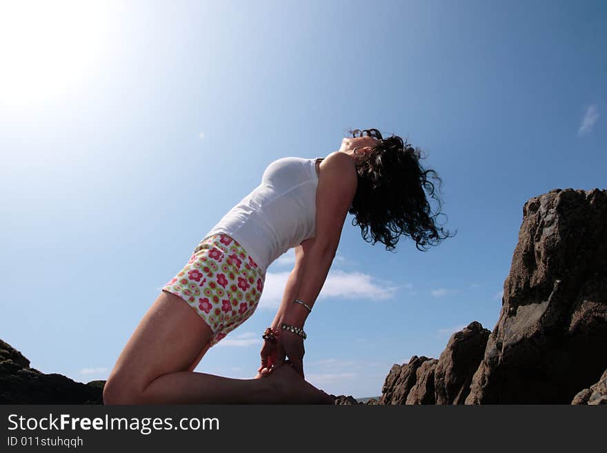 A beautiful woman doing yoga to show a healthy way to live a happy and relaxed lifestyle in a world full of stress. A beautiful woman doing yoga to show a healthy way to live a happy and relaxed lifestyle in a world full of stress