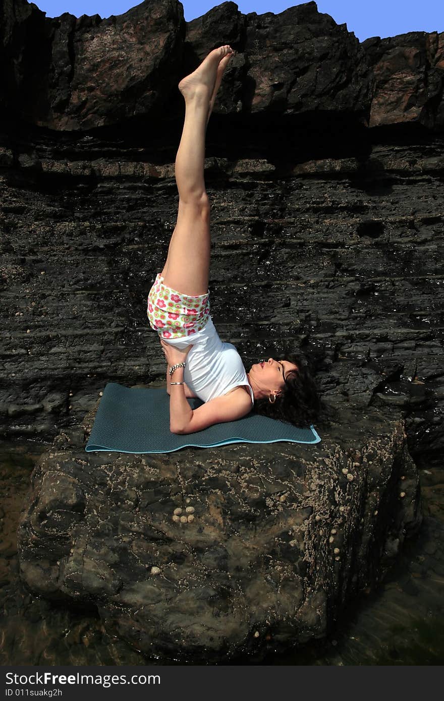 A beautiful woman doing yoga to show a healthy way to live a happy and relaxed lifestyle in a world full of stress. A beautiful woman doing yoga to show a healthy way to live a happy and relaxed lifestyle in a world full of stress