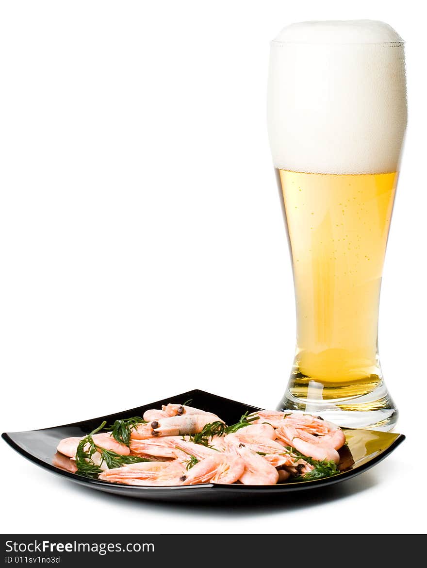 Beer in a glass and a dish with shrimps on a white background