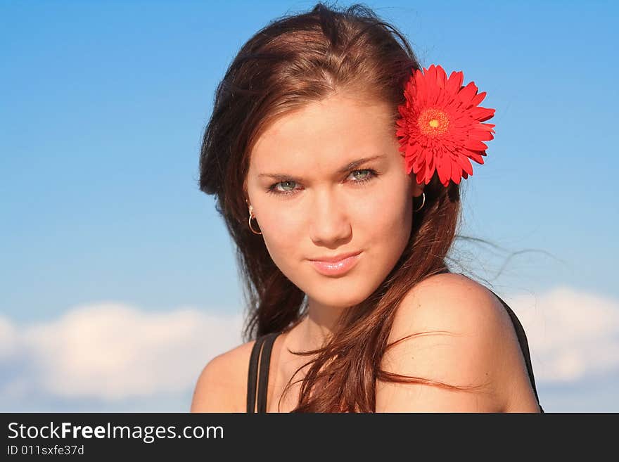 Young brunette girl with daisy in her hair. Young brunette girl with daisy in her hair