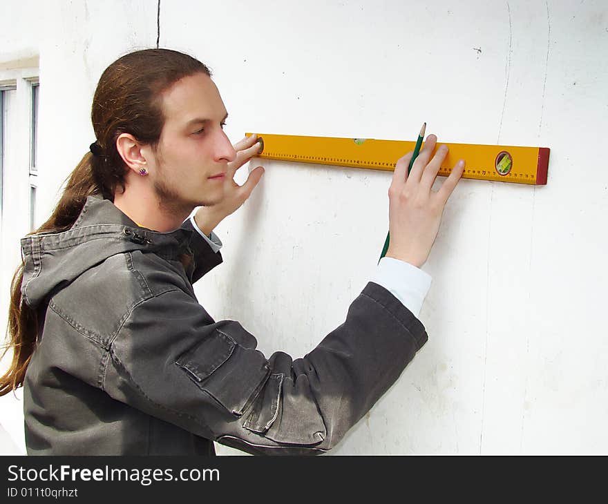 Young adult man draws on a wall. Repair. Young adult man draws on a wall. Repair.