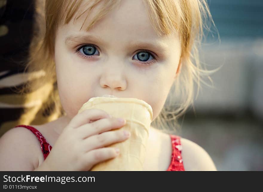 The girl eats, thinking, outdoors