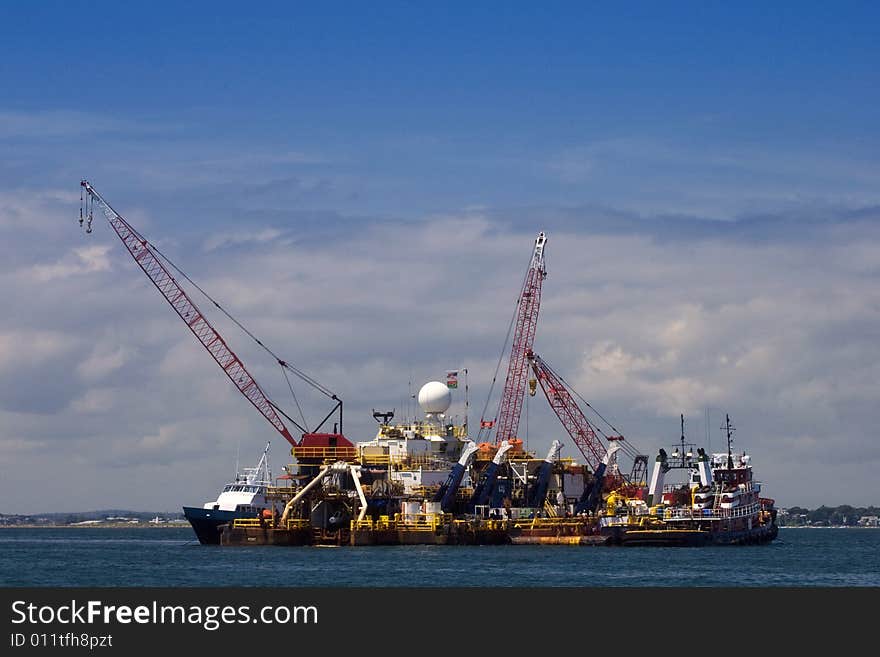 A shipping barge on Boston Harbor with cranes