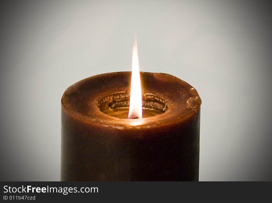 A candle burning and isolated on a dark background. A candle burning and isolated on a dark background