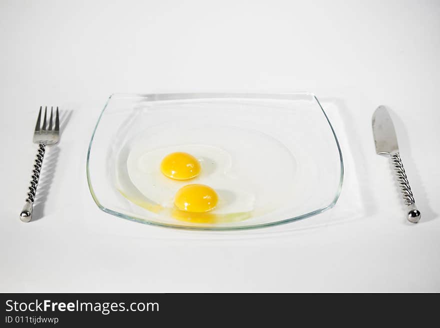 Two raw egg yolk on a plate and isolated on a white background. Two raw egg yolk on a plate and isolated on a white background