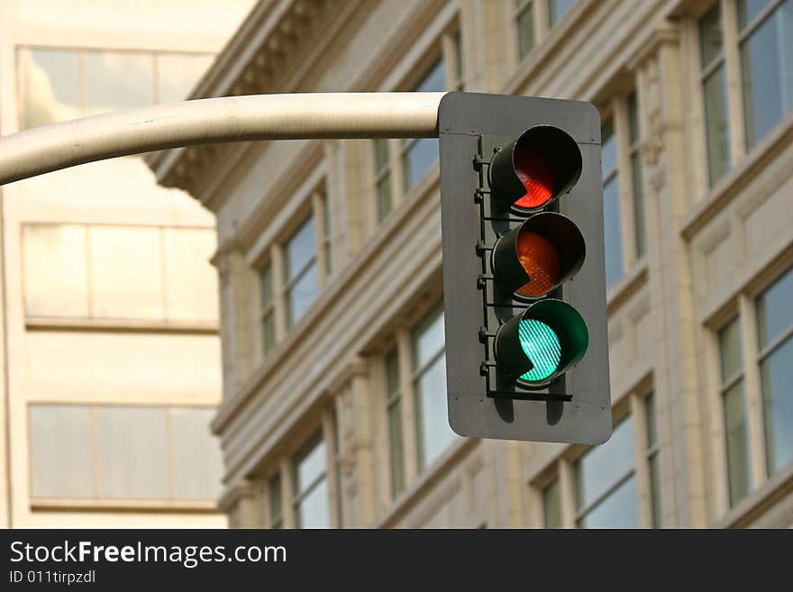 Green stoplight against the city