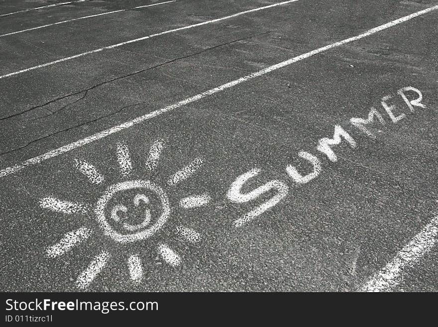 A drawing of a sun and the word summer written on a parking lot with chalk and isolated on a white background. A drawing of a sun and the word summer written on a parking lot with chalk and isolated on a white background