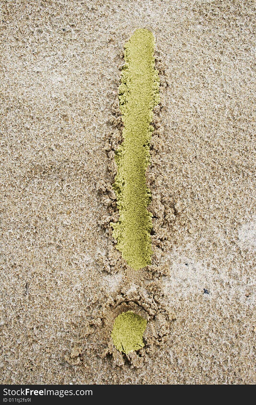 Light yellow exclamation mark on fine sand. Light yellow exclamation mark on fine sand