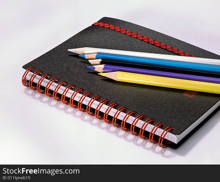 Black Note Book With Colored Pencils