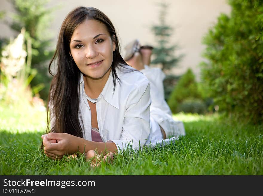 Happy brunette woman lying on grass. Happy brunette woman lying on grass