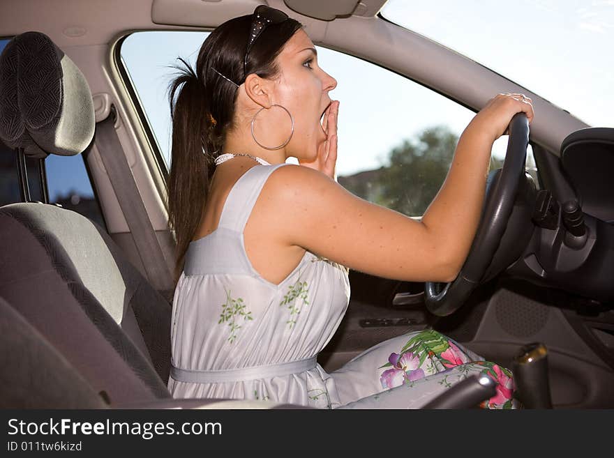 Attractive brunette woman driving a car. Attractive brunette woman driving a car