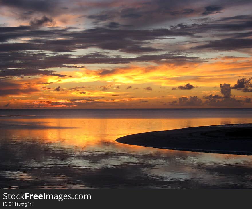 Glorious sunset mirrored in calm surface of the ocean. Glorious sunset mirrored in calm surface of the ocean