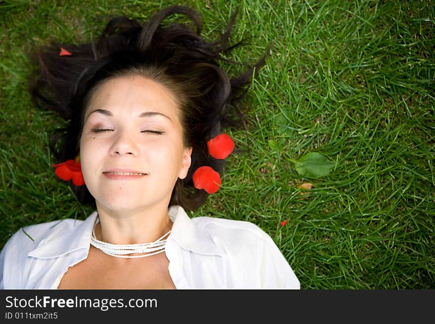 Happy brunette woman lying on grass. Happy brunette woman lying on grass